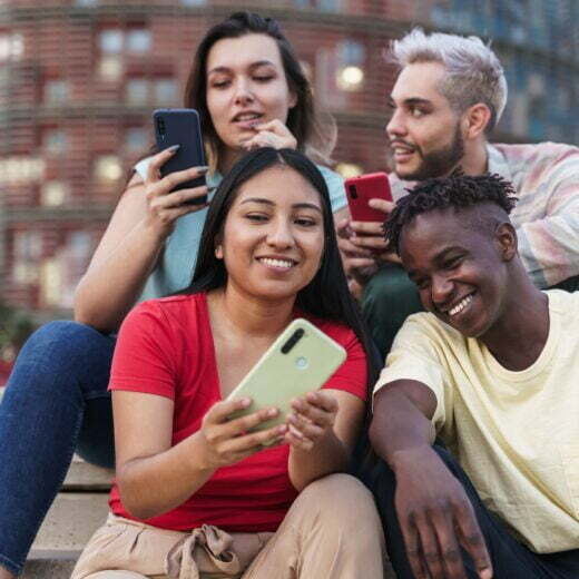Group of friends using smartphones outdoors